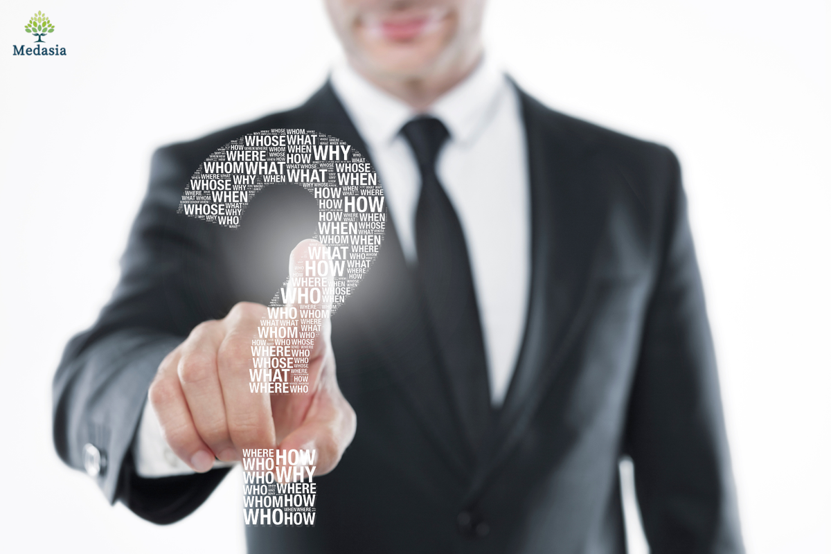 Businessperson pointing to a question mark, illustrating how to choose a medical device sourcing agent in China